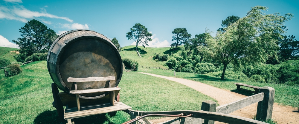 乡村农业景观背景中绿草场上推车上酒桶的复古风格形象有机食品酒厂和酒精饮料产品行业